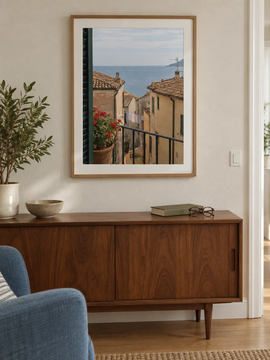 Küstenfoto in einem naturfarbenen Holzrahmen über einem Nussbaum-Sideboard