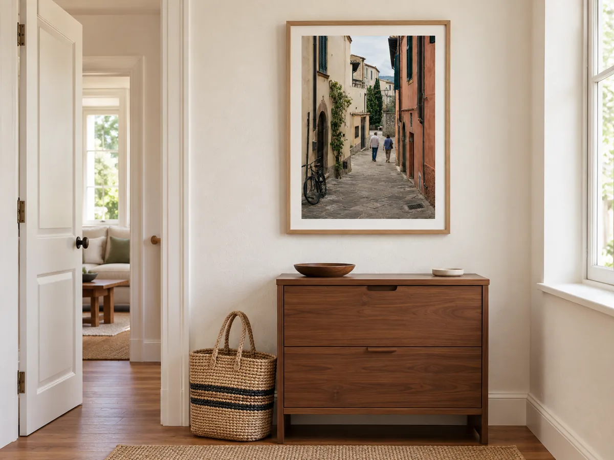 Foto einer italienischen Gasse in einem naturfarbenen Holzrahmen über einem Flurschrank